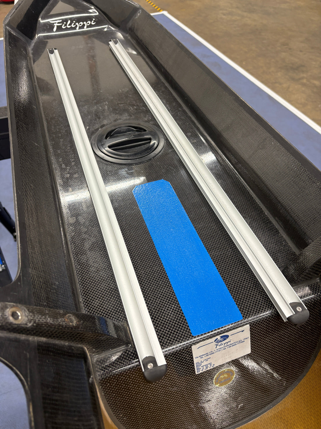 Interior cockpit of a rowing shell with newly installed seat tracks and clean hardware for spring season preparation.